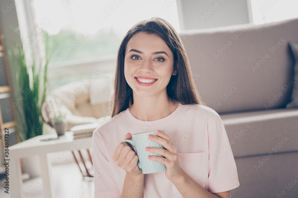 Photo portrait of attractive woman holding cup in two hands smiling indoors Photo portrait of attractive woman holding cup in two hands smiling indoors