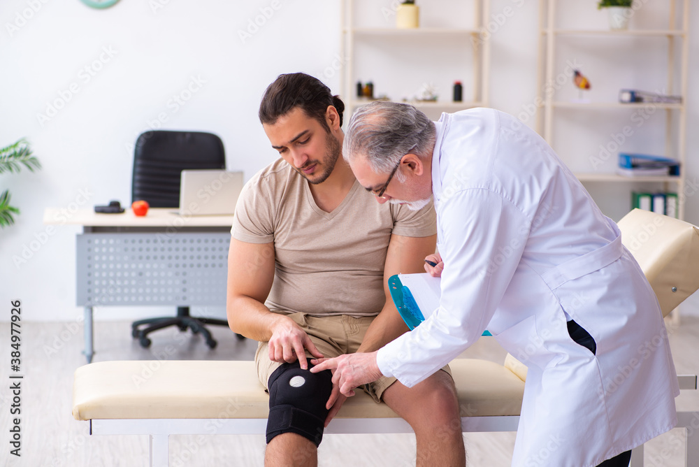 Obraz premium Experienced doctor traumatologist examining young male patient
