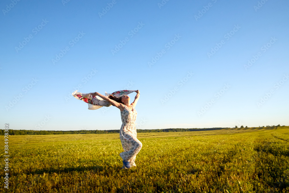 Beautiful woman or girl with magnificent figure and plastic movements walking and dancing in green field with trimmed grass in the setting sun during sunset with warm yellow light. Beautiful woman or girl with magnificent figure and plastic movements walking and dancing in green field with trimmed grass in the setting sun during sunset with warm yellow light.