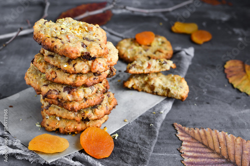 Oatmeal cookies. Homemade baking. Autumn concept of cookies with dried apricots and chocolate. Copy space. Dark background.