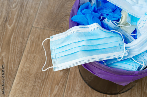 Used infectious masks and medical glove in the trash bin