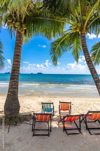 A beautiful beach with coconut trees in front of the sea and sky in the background with chair at Koh Chang  Thailand. Copy space background