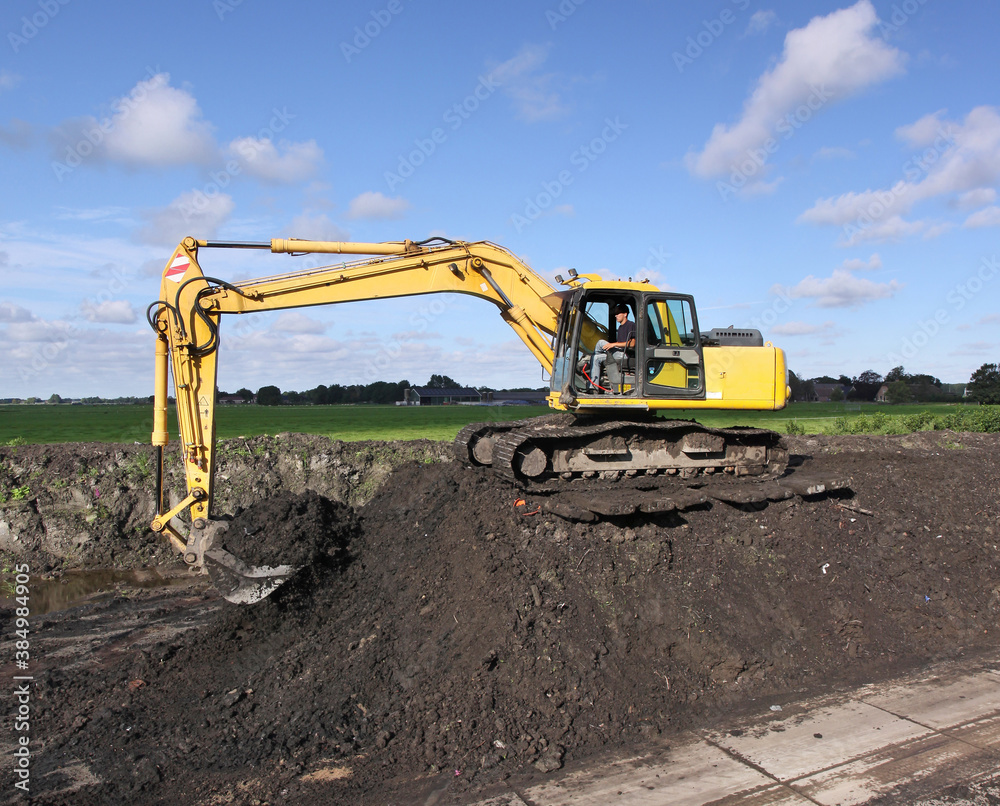 Obraz premium A crane filling a trailer with ripened dredging spoil from a storage compartment 