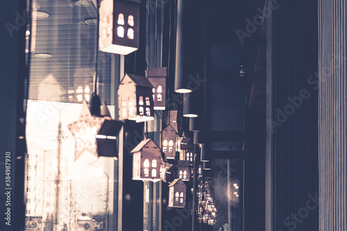 Decorations in the form of glowing lanterns on the window of the cafe. Christmas decorations. Background. Copy space.