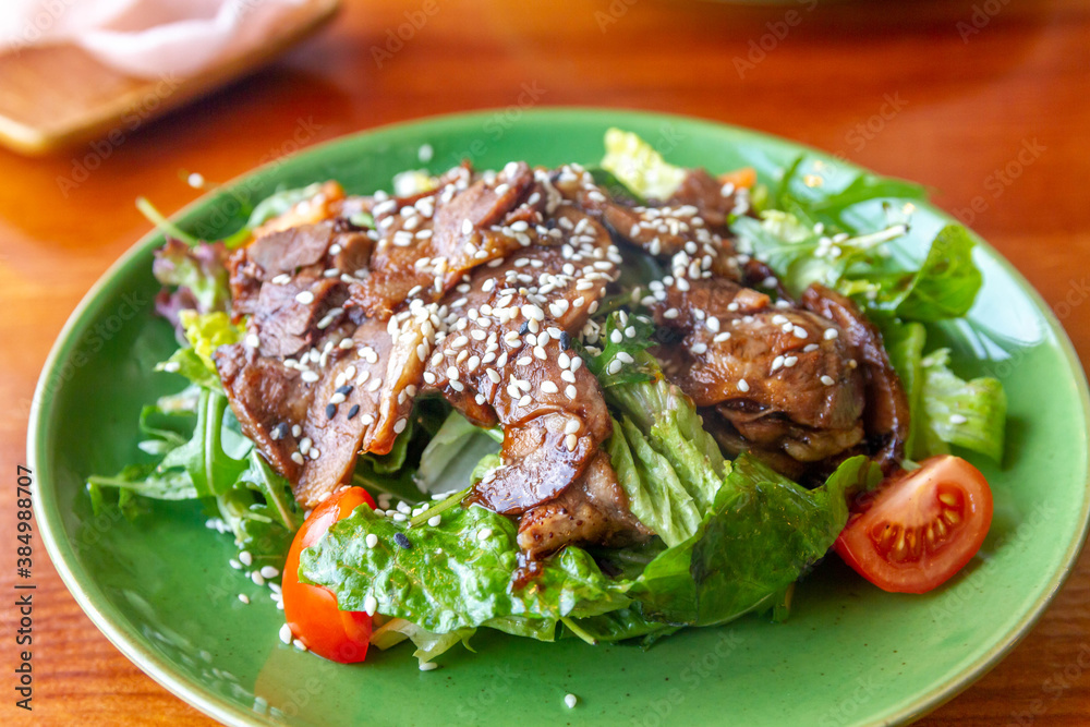 Green plate with lettuce and tongue, cherry tomatoes, sesame seed. Green plate with lettuce and tongue, cherry tomatoes, sesame seed.