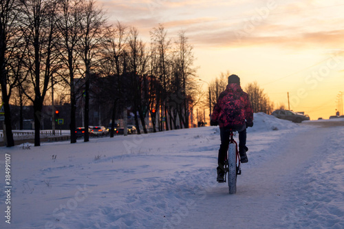 A man rides a Bicycle through the snow in winter.