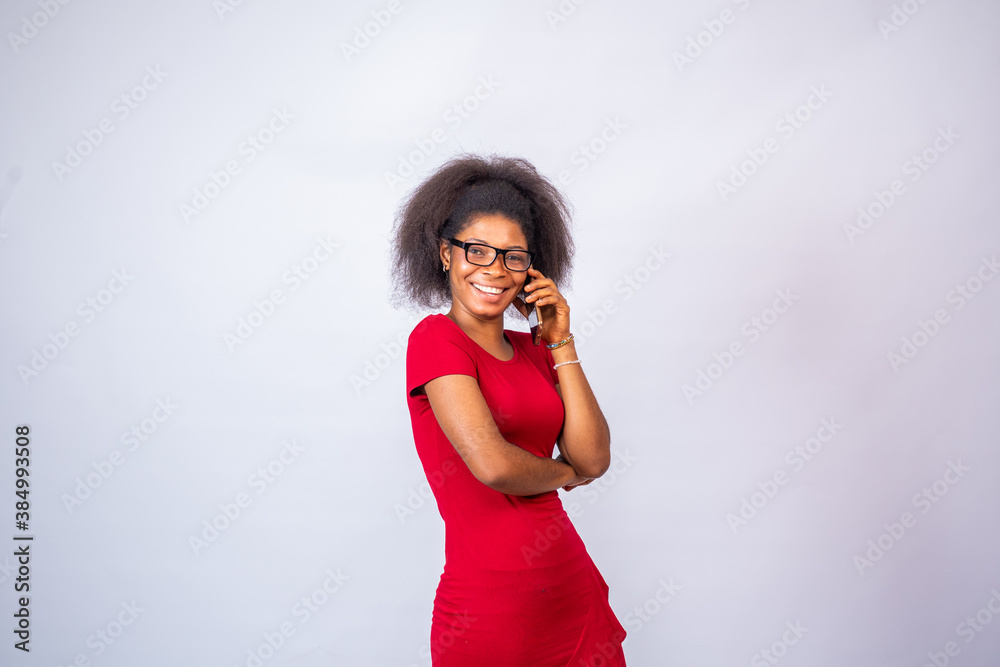 smiling african woman wearing a red dress and glasses making a phone ...