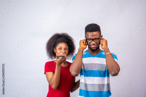 Canvas Print young african lady making a phone call too close to a man who is blocking his ea
