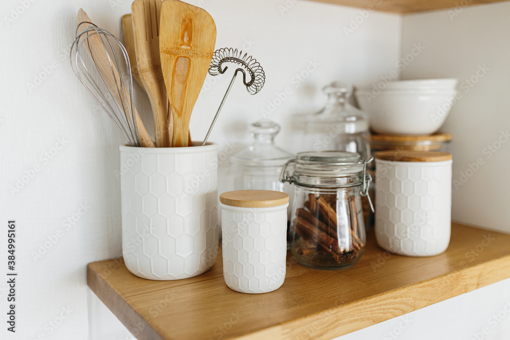 Kitchen shelves with various white ceramic and glass jars.