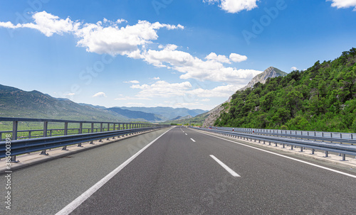 Mountain highway with blue sky and rocky mountains on a background