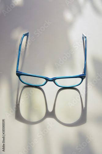Rectangular glasses in bright blue frames close-up on a light background