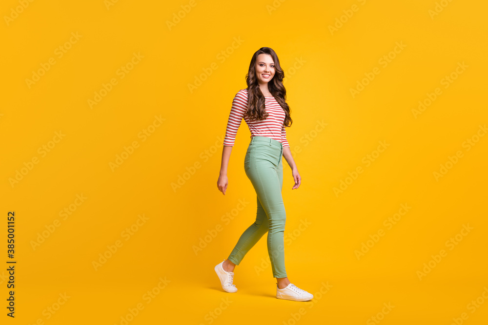 Full length body size side profile photo of girl with curly hair hurrying up smiling isolated on vivid yellow color background - obrazy, fototapety, plakaty 