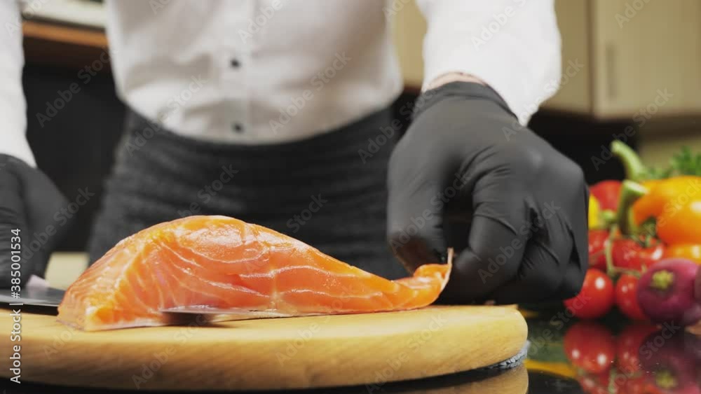 Chef removes skin of a salmon fish. Descale skin from salmon fillet