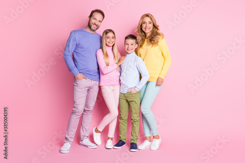 Full length photo of cheerful family with dad daddy mom mommy two kids stand isolated over pink color background