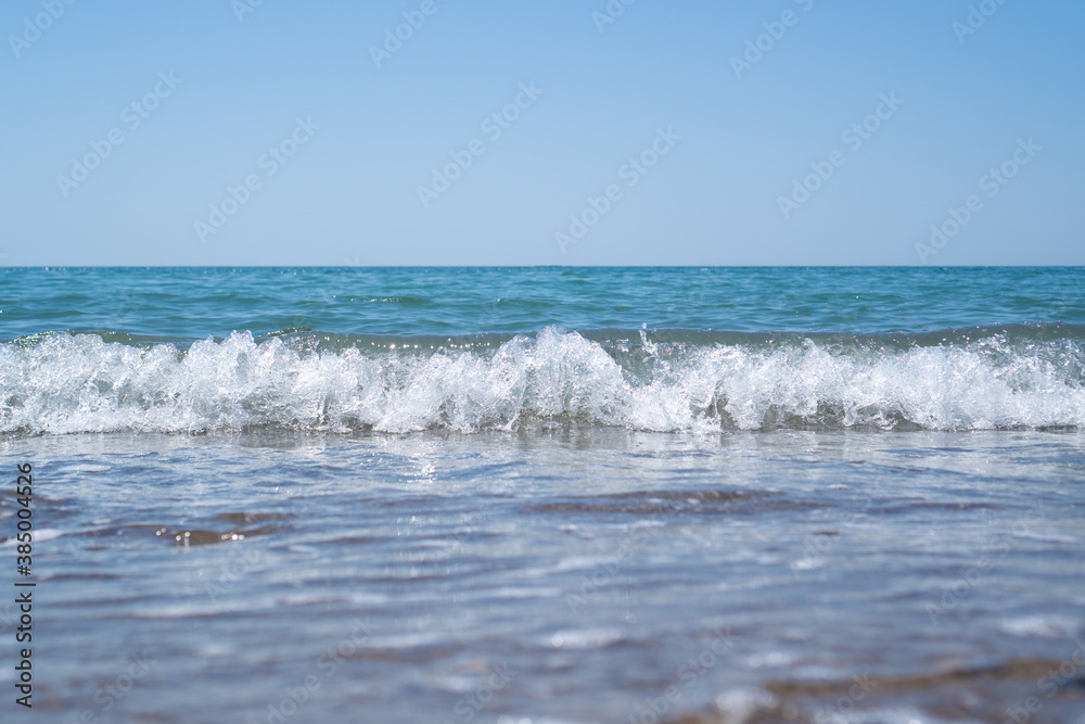 Soft selective focus of small sea wave. Bright light blue and white wave. wallpaper of sea meditation. Rest, calm.