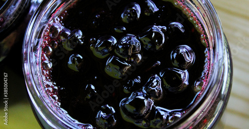 Banner of chokeberry jam in a glass jar. Sweet from aronia.