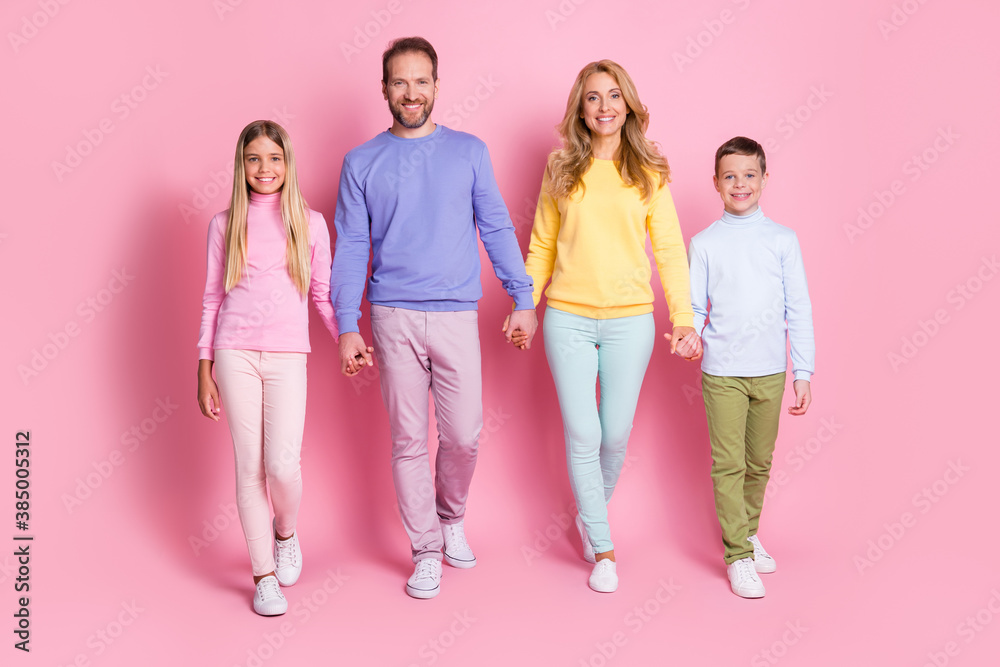 Obraz premium Full size photo of positive family daddy mommy small boy girl hold hand go isolated over pastel color background