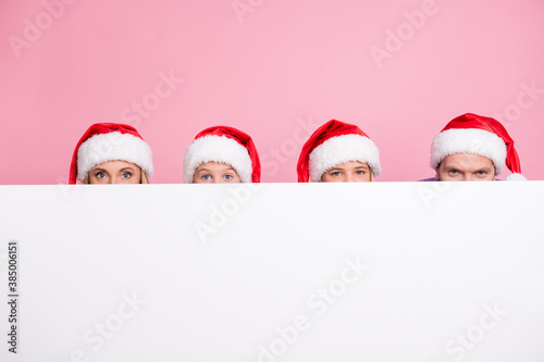 Photo of people mom mommy dad daddy little kids hide faces on white copy space wear santa claus cap isolated pink color background © deagreez