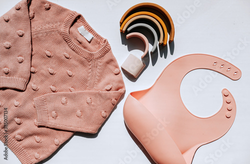 Bilde på lerret Set for girls, pink sweater, silicone bib and toy rainbow