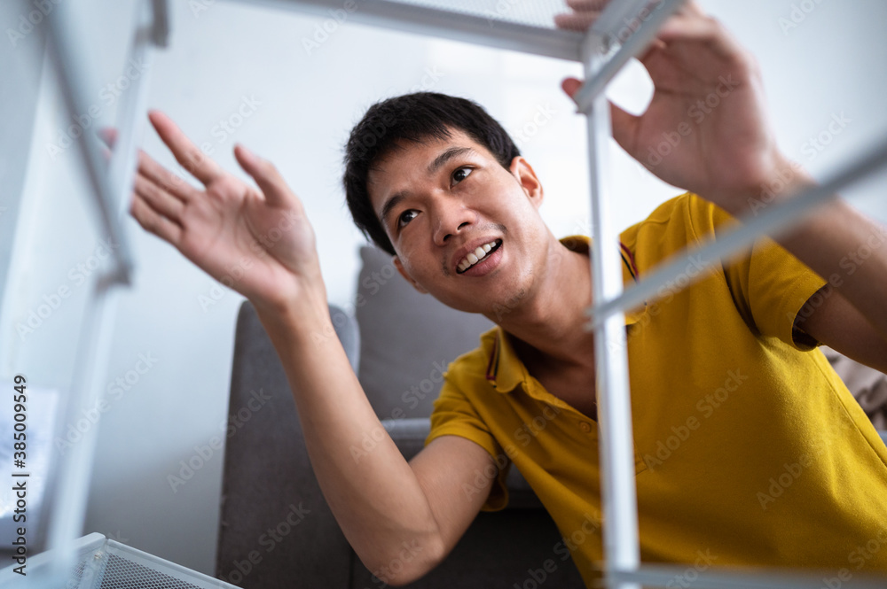 Asian men assembling furniture in the living room at home. Asian men assembling furniture in the living room at home.