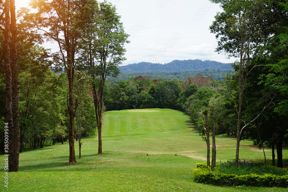Background of evening golf course has sunlight shining down at golf course in Thailand. Nice scenery on a golf course at a late summer afternoon