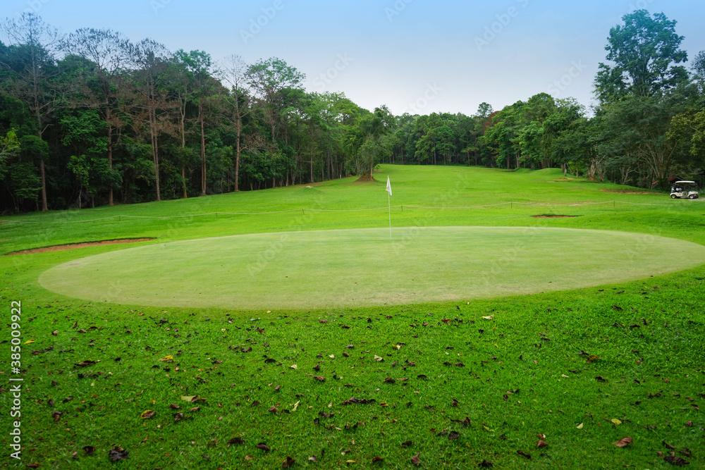 Background of evening golf course has sunlight shining down at golf course in Thailand. Nice scenery on a golf course at a late summer afternoon