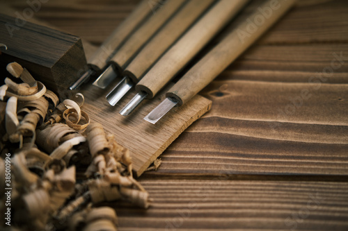 Close up view of a set of wood chisels for carving wood, sculpture tools on wooden background