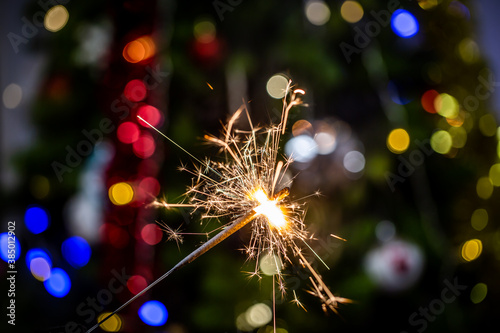 Sparkler and Christmas tree on background