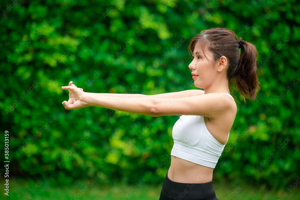 Young asian women warm up in a park before jogging. Young asian women warm up in a park before jogging.