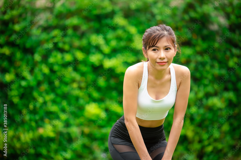 Young asian women warm up in a park before jogging. Young asian women warm up in a park before jogging.