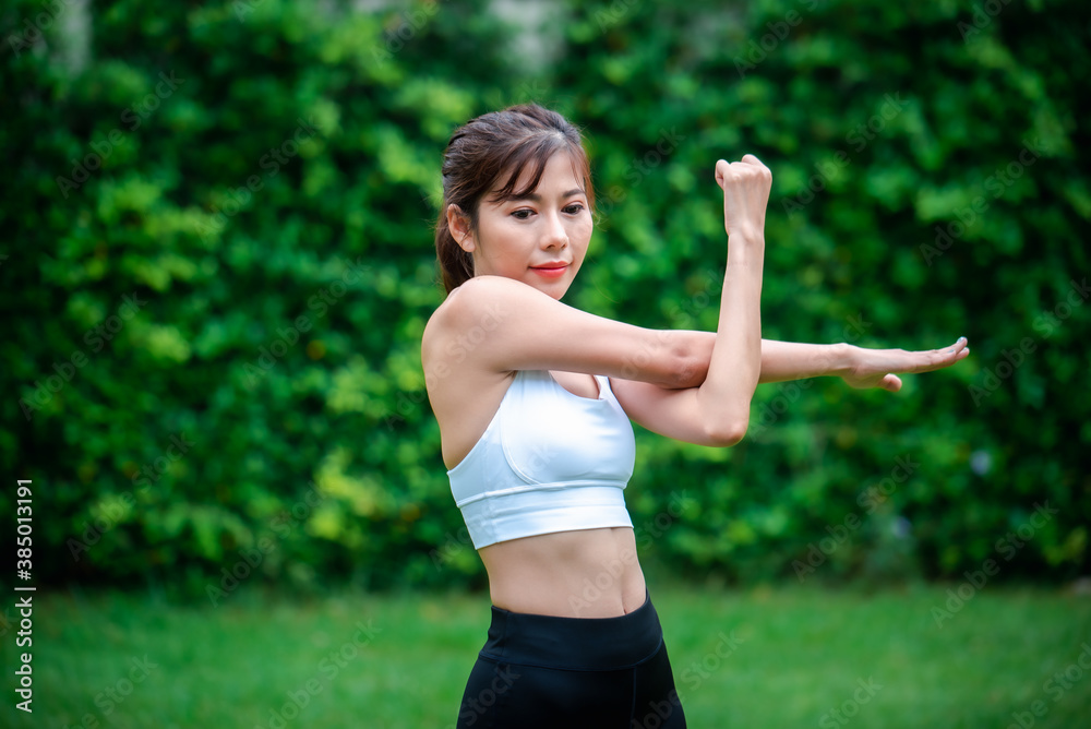 Young asian women warm up in a park before jogging. Young asian women warm up in a park before jogging.