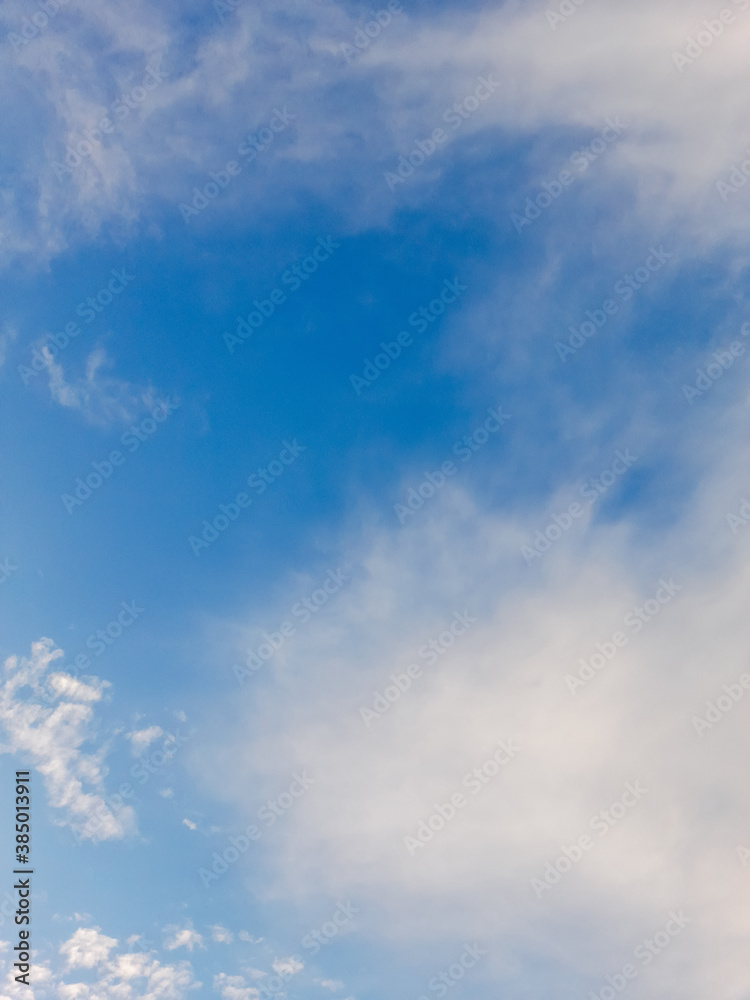 the pale blue sky is covered with sparse white clouds. air clouds against the blue sky the pale blue sky is covered with sparse white clouds. air clouds against the blue sky