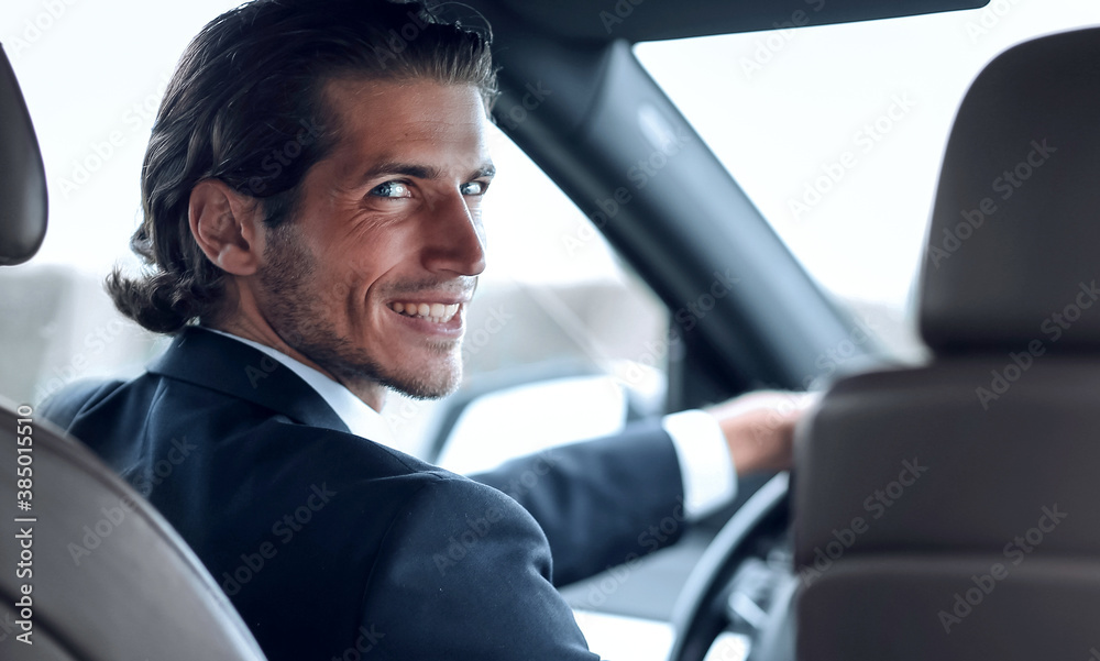 man sitting behind the wheel of a car man sitting behind the wheel of a car