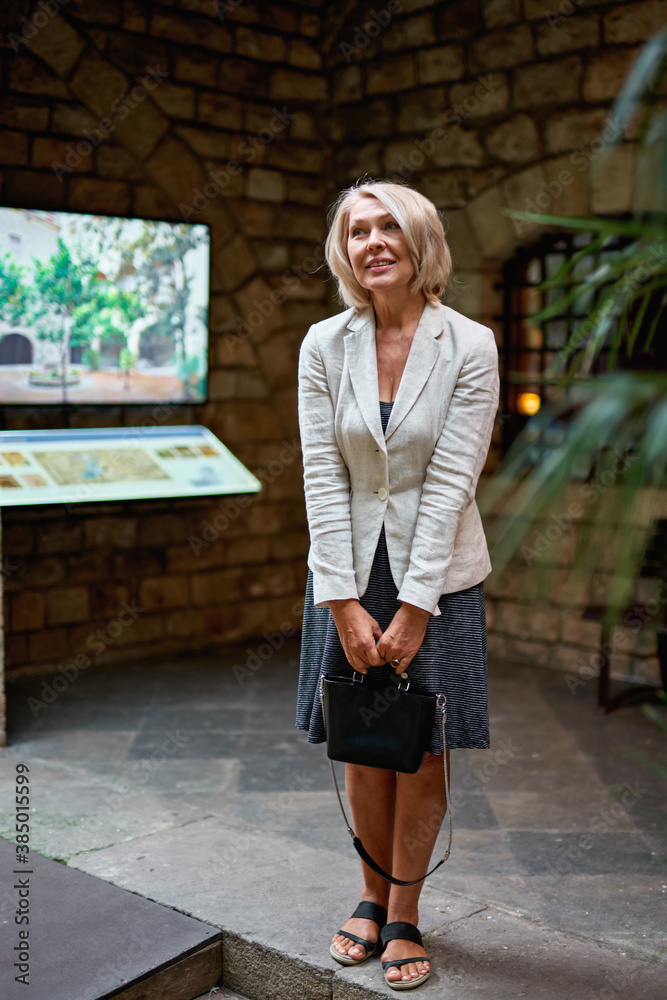 woman in museum near touchscreen monitor electronic guide