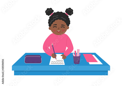 Cute african girl writes on the paper at the desk. School child at the table. 