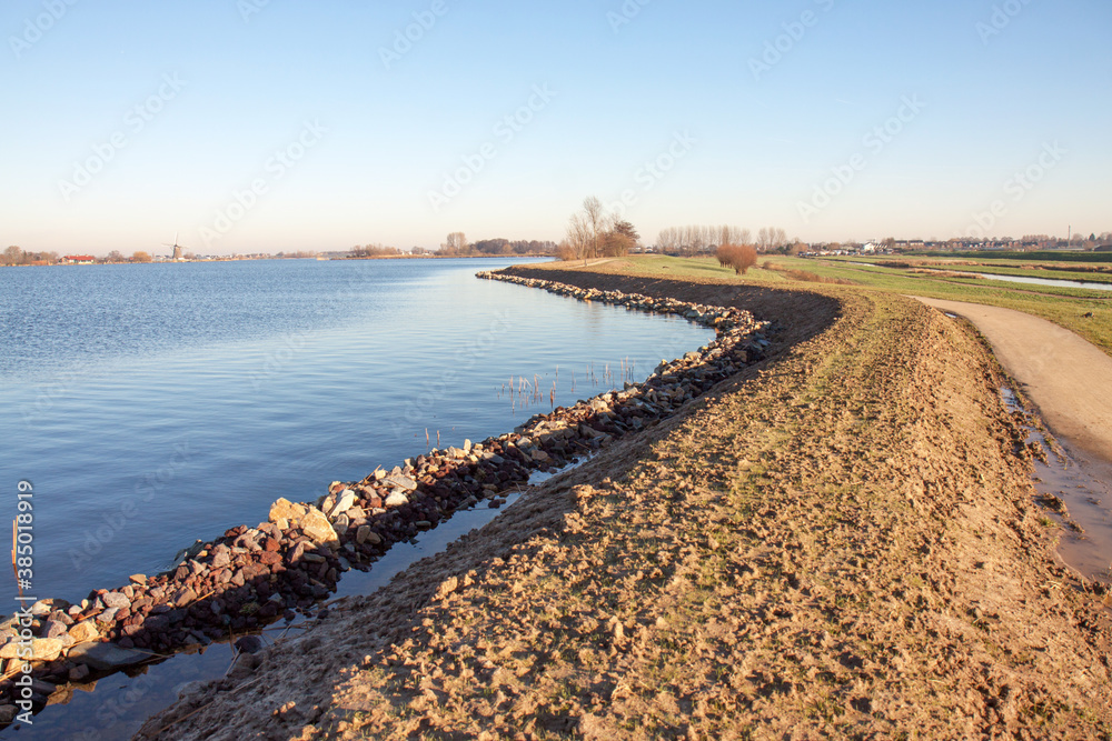 Recently reenforced dike with rubble to protect the shoreline (left), a raised clay-bar to prevent water from washing over the dike and a cyclepath on top of the dike. 