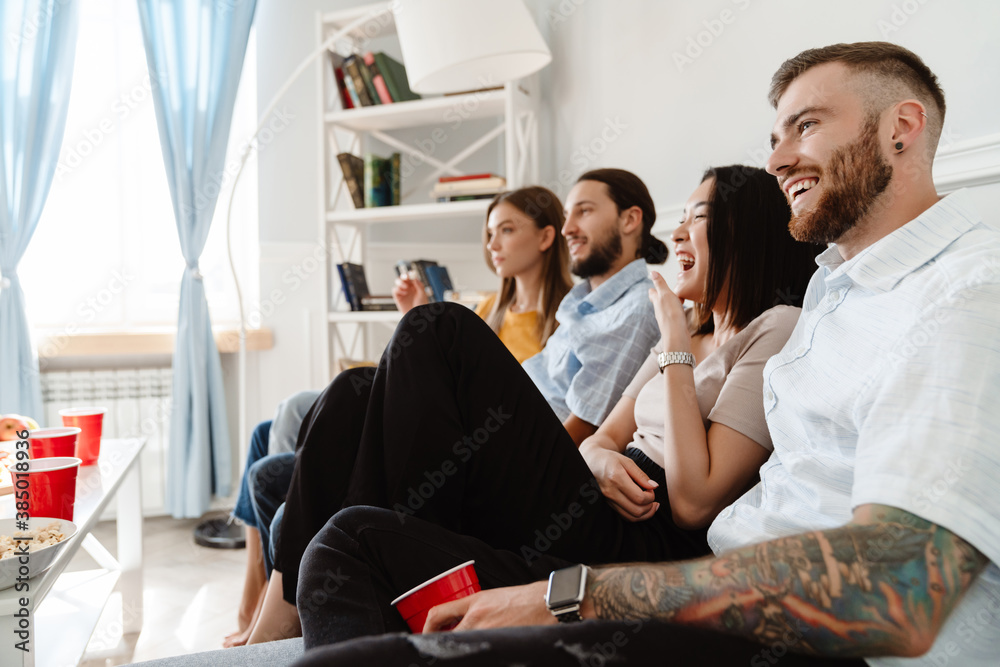 Obraz premium Image of friends drinking beverage and eating popcorn while watching movie