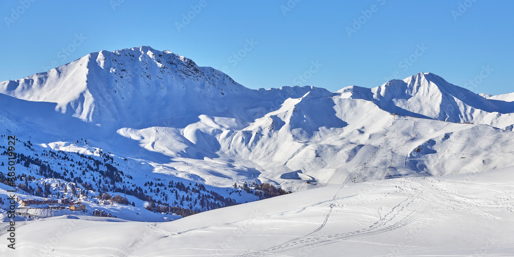 Panoramic view of the snowy high-altitude mountain range near the  Tignes ski resort in France during the winter season.