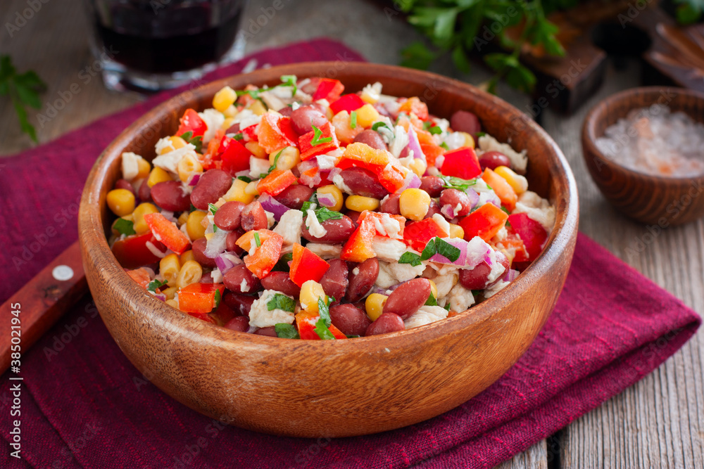 salad with red beans, corn and bell peppers in a wooden salad bowl, selective focus