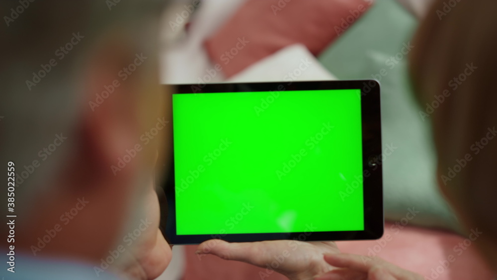 Mature man and woman using tablet with chroma key. Older couple holding pad
