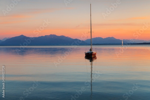 Sailing boat at sunset, Lake Chiemsee and Chiemgau Alps, Upper Bavaria photo