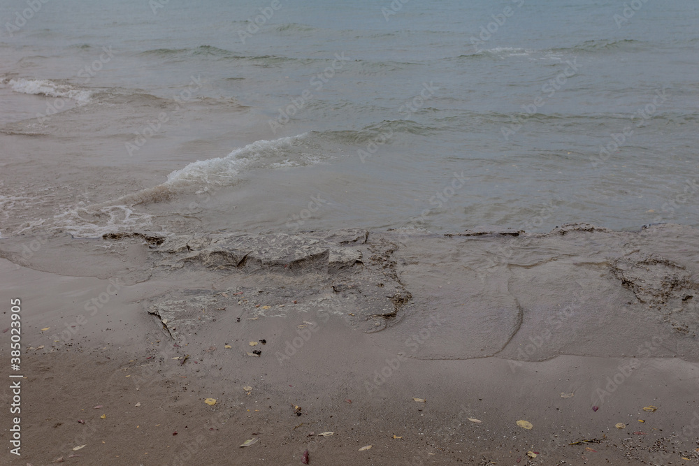 Lake water washing over worn rocks on overcast day Lake water washing over worn rocks on overcast day