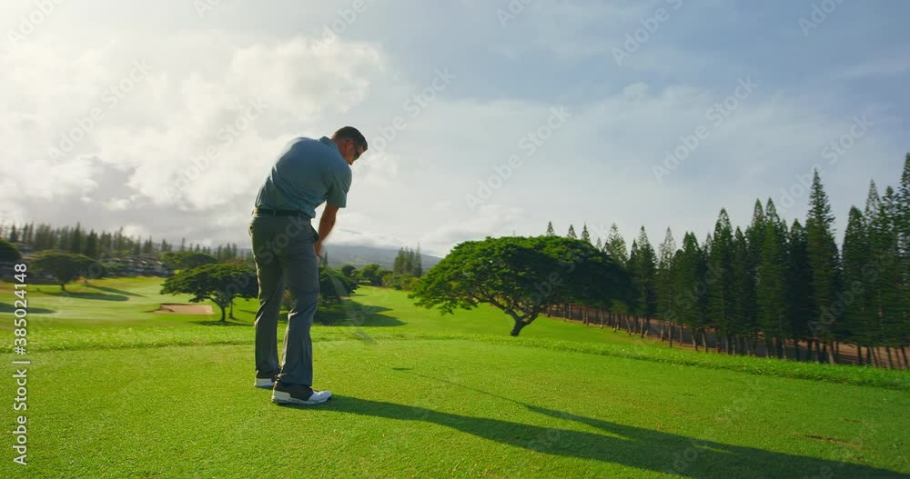 Sunrise golf, man swinging and hitting golf ball in slow motion