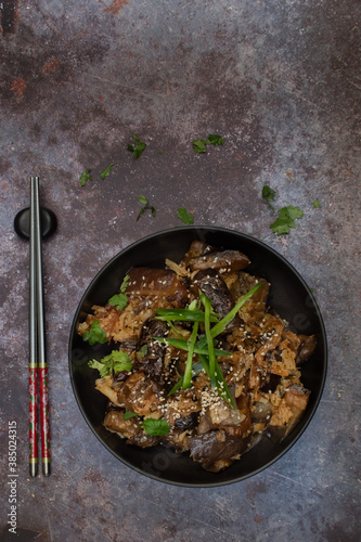 Korean vegan braised eggplant gaji namul  served in dark bowl