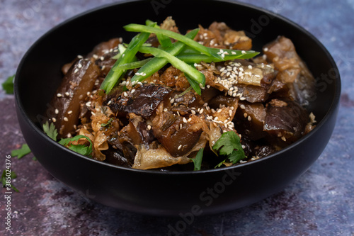Korean vegan braised eggplant gaji namul served in dark bowl