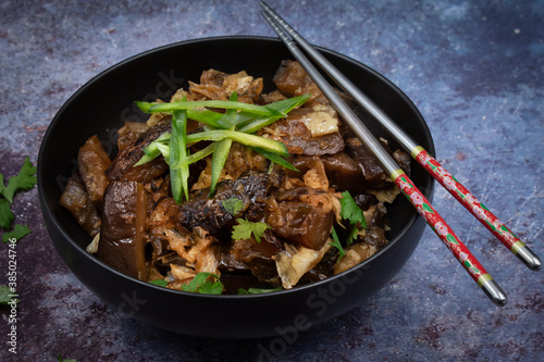 Korean vegan braised eggplant gaji namul  served in dark bowl photo