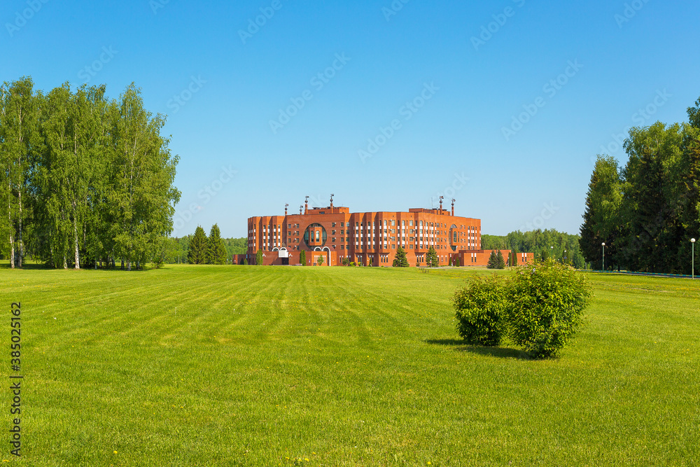 A delightful green field with spring mown grass, trees and a building A delightful green field with spring mown grass, trees and a building