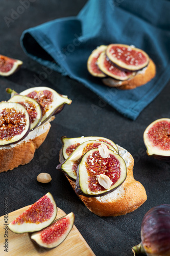 Tasty bruschetta with cream cheese, figs