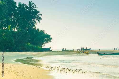 Fishermen and wading birds at beautiful Kizhunna Beach, south of Kannur on the Kerala north coast, Kizhunna, Kannur, Kerala, India photo