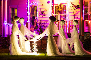 Illuminated Halloween house ghosts decoration at night